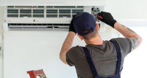 Мужчина устанавливает кондиционер - РИА Новости, 1920, 27.03.2026