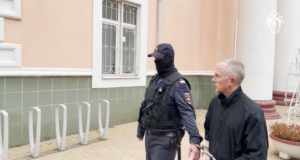 Мужчина, обвиненный в изнасилованиях и убийствах девушек 20-летней давности, в сопровождении сотрудника полиции - РИА Новости, 1920, 28.03.2026