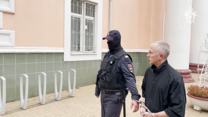 Мужчина, обвиненный в изнасилованиях и убийствах девушек 20-летней давности, в сопровождении сотрудника полиции - РИА Новости, 1920, 28.03.2026