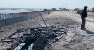 Сотрудник Следственного комитета РФ на поврежденной дороге на Чонгарском мосту - РИА Новости, 1920, 09.06.2026