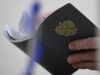Сотрудник Центра занятости населения держит в руках трудовую книжку посетителя - РИА Новости, 1920, 01.07.2026