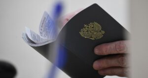В Нерехте глава семьи с 6 детьми без работы сам отказывался от вакансий Сотрудник Центра занятости населения держит в руках трудовую книжку посетителя - РИА Новости, 1920, 01.07.2026