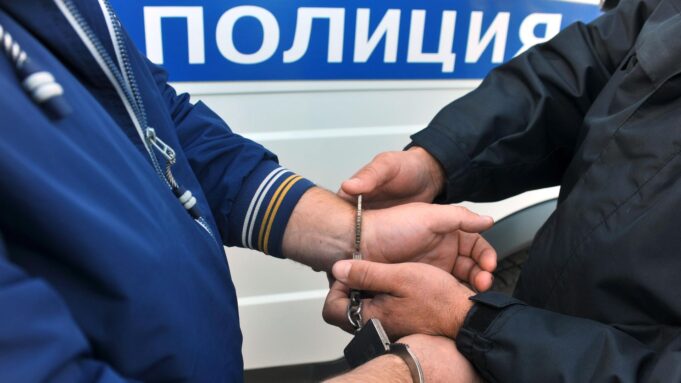 Суд арестовал иностранцев с «Садовода» на десять суток за пропаганду ЛГБТ Сотрудник полиции надевает наручники на правонарушителя - РИА Новости, 1920, 24.08.2026